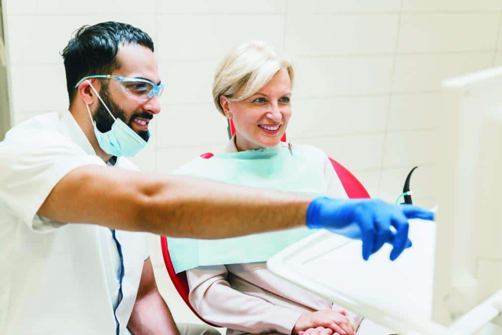 Orthodontist explaining X-ray photo on patient