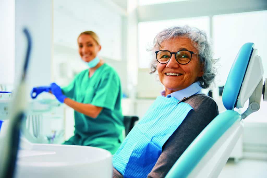 Happy senior smiling, looking at the cameras at the dentist's office